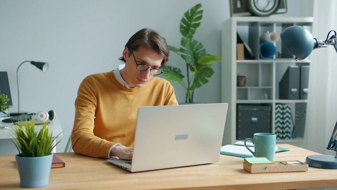 programmer typing on laptop at desk