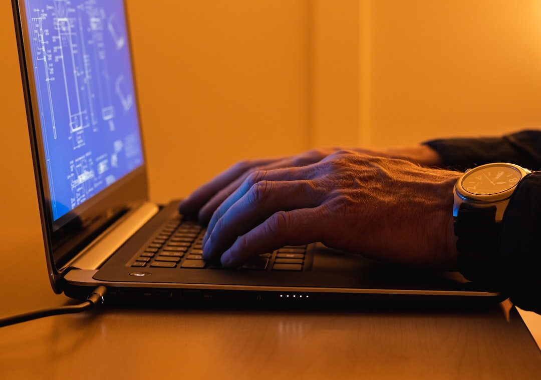 programmer typing on laptop at desk